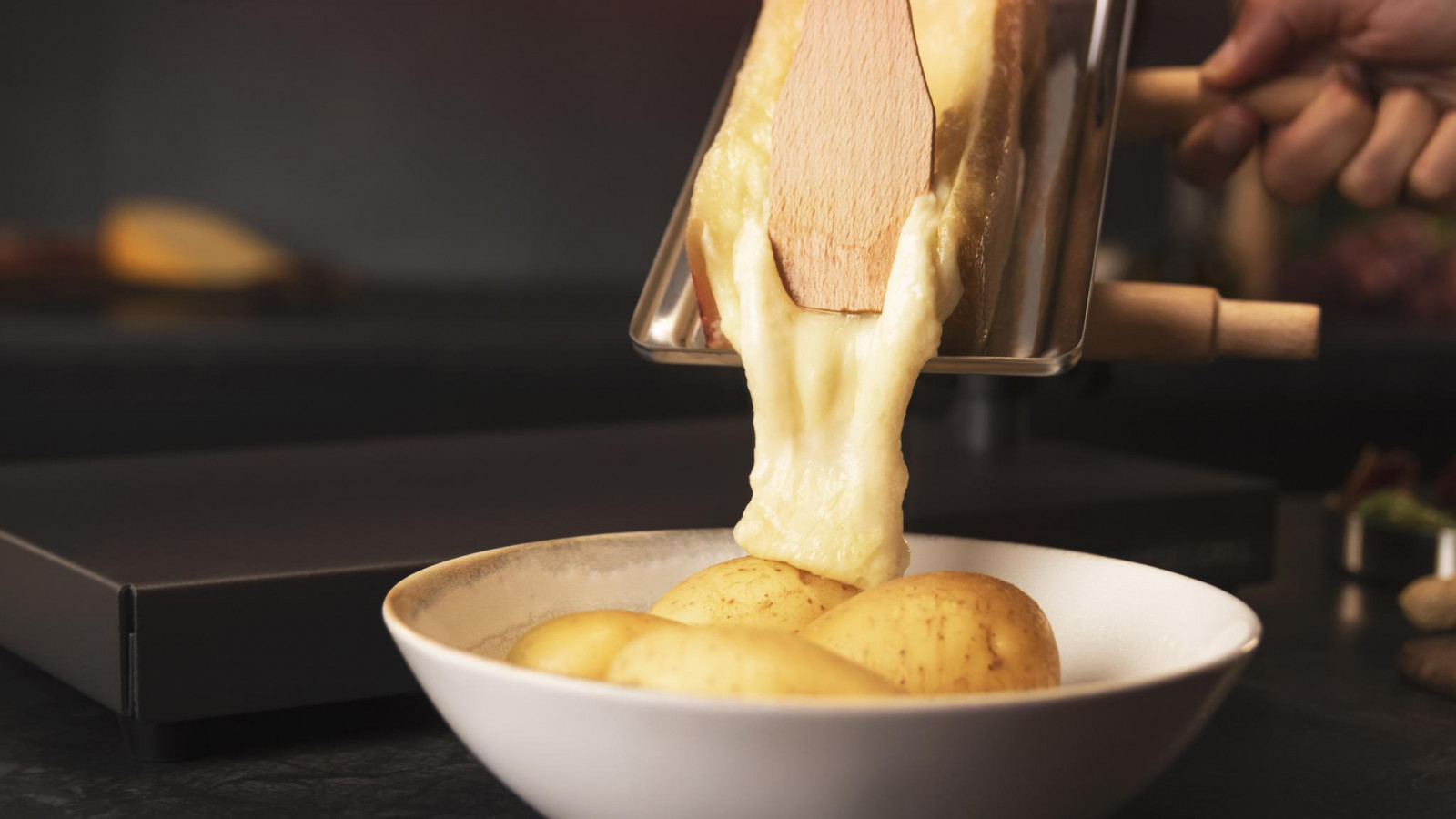 Material antiadherente en la parrilla superior que ayudará a obtener una fácil y rápida limpieza. Por otro lado, cuenta con un mango giratorio y reclinable para ajustar la altura de la raclette, además de soporte para queso extraíble con asas de madera.