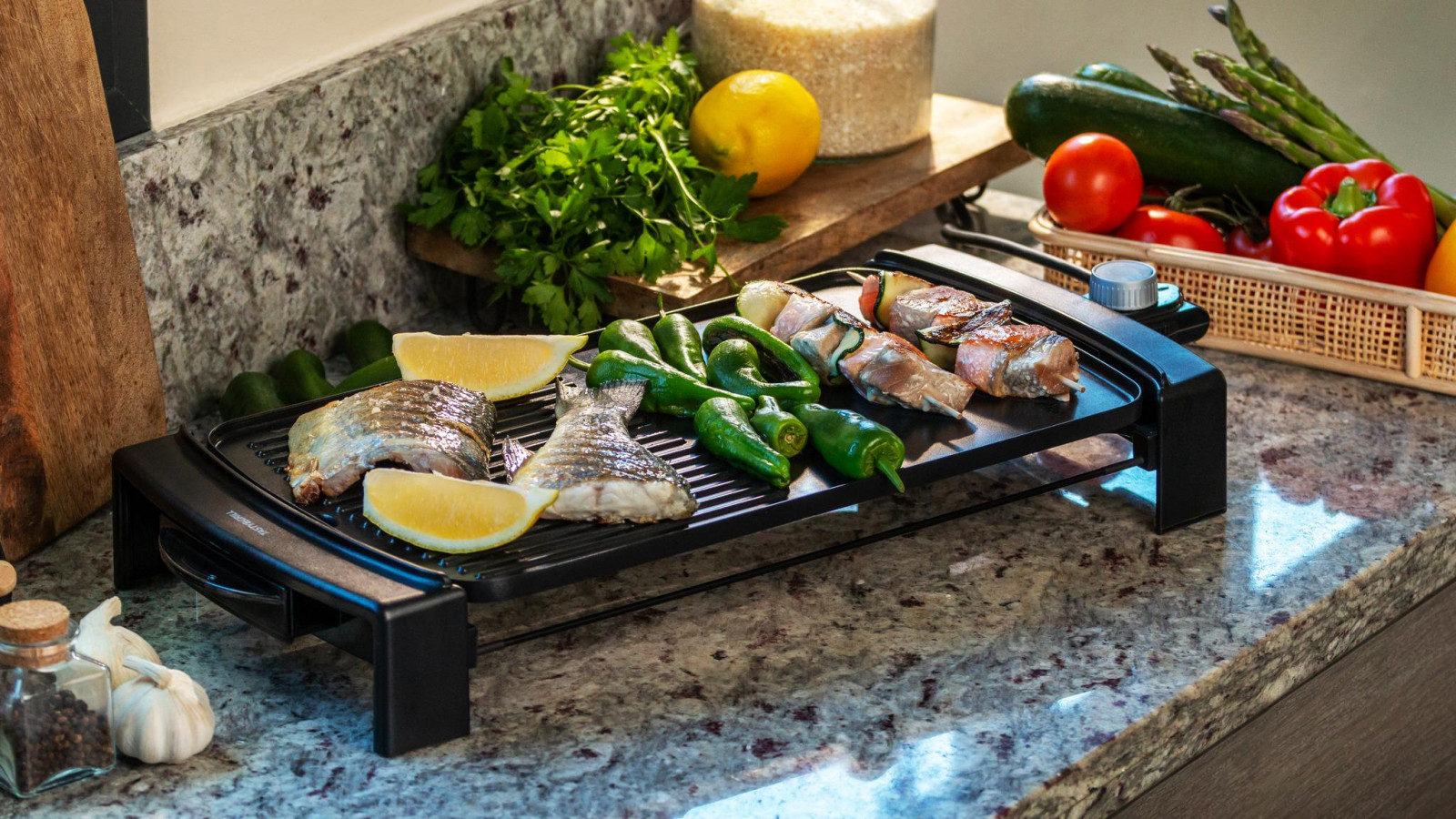 Plancha de asar eléctrica de 2150 W de potencia para cocinar todo tipo de alimentos de forma rápida y precisa, y asas de tacto frío para un manejo más cómodo.